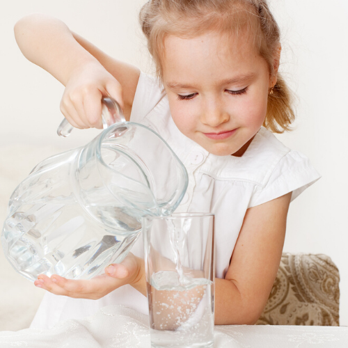 girl pouring water into a glass